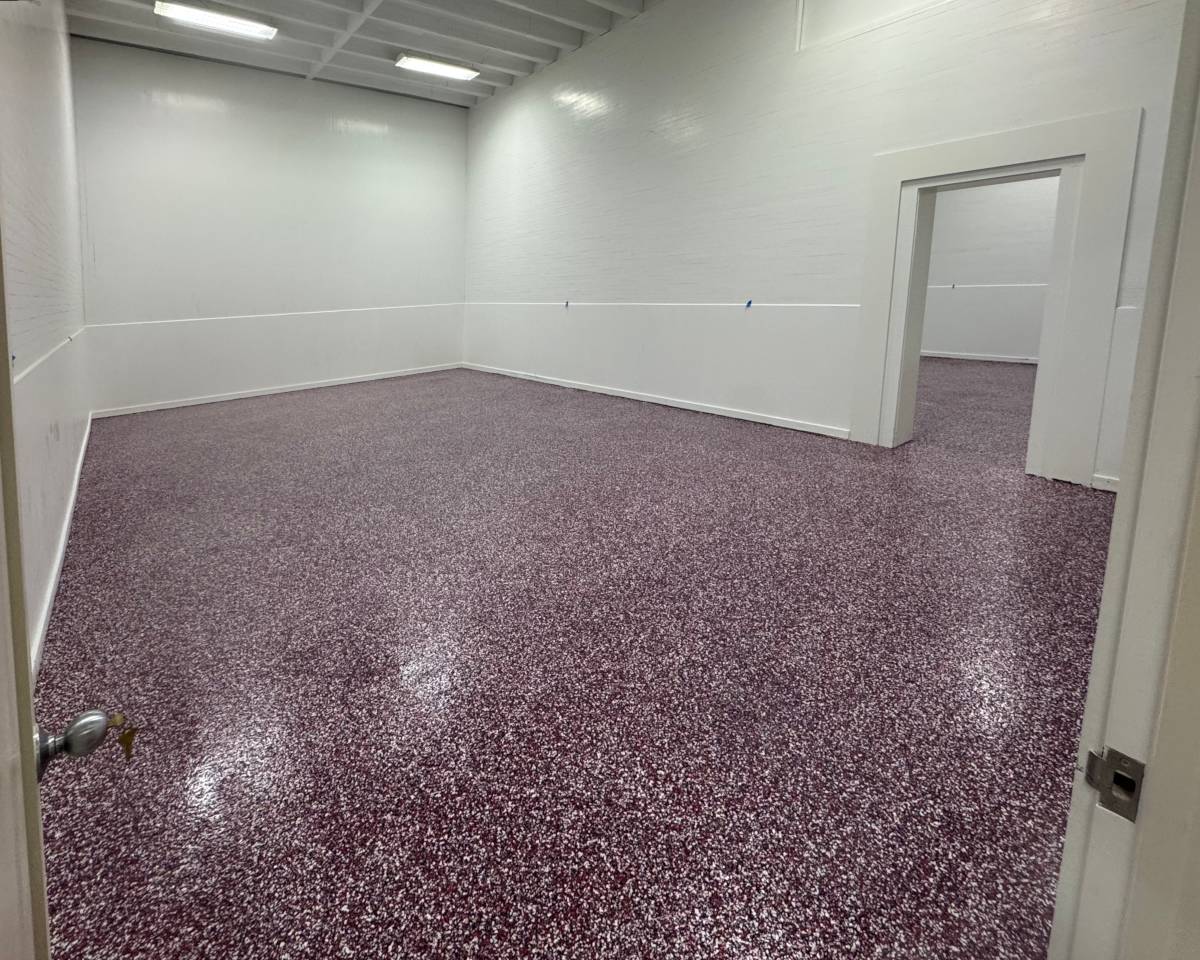 an epoxy floor in a commercial setting with a red white and black flake color