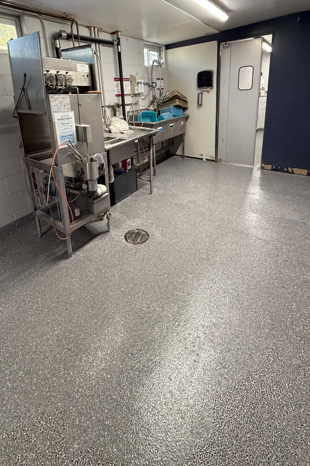 a commercial setting with an epoxy floor with grey white and black flake color